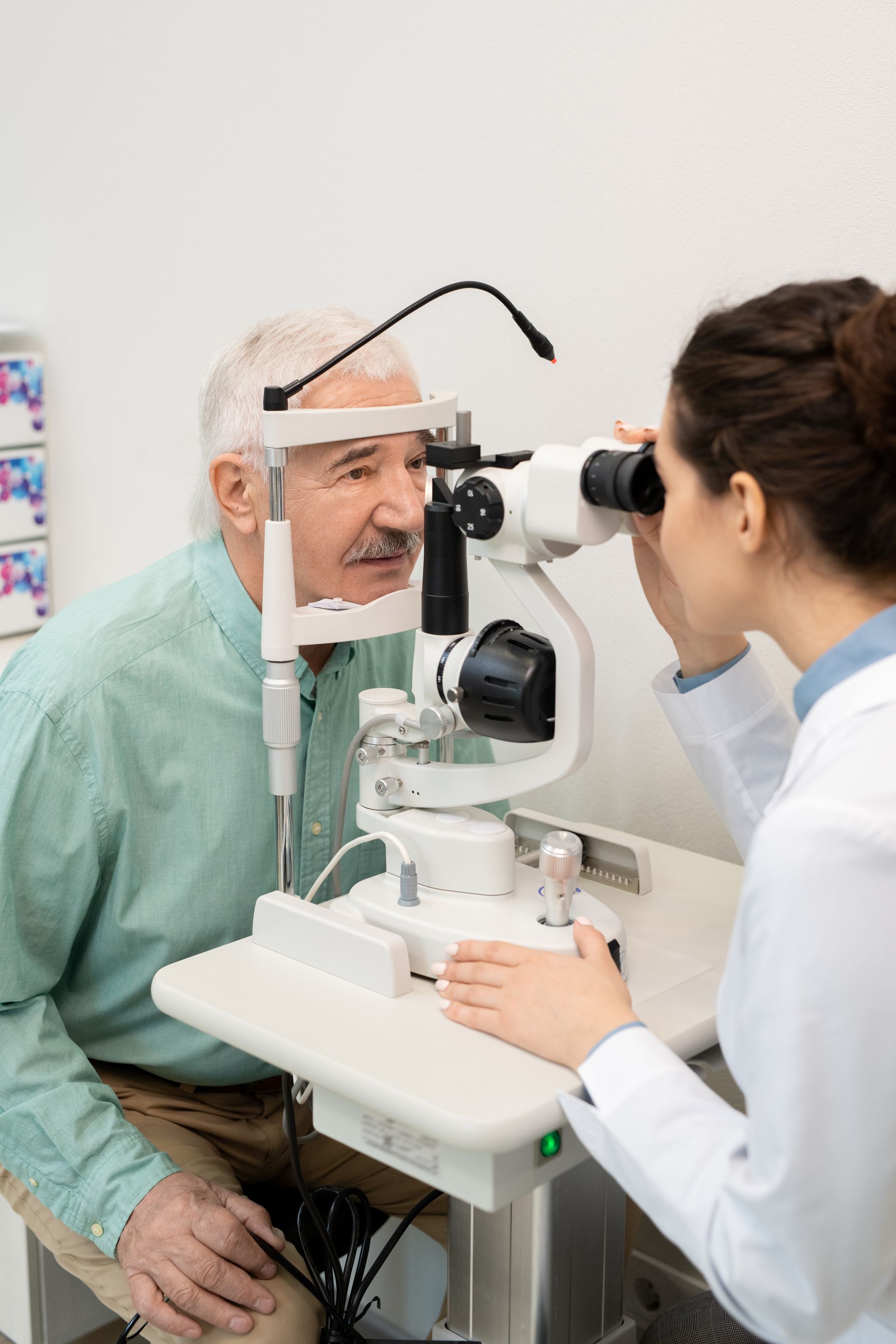 Doctor and patient at an eye exam with a slit lamp in a clinic.