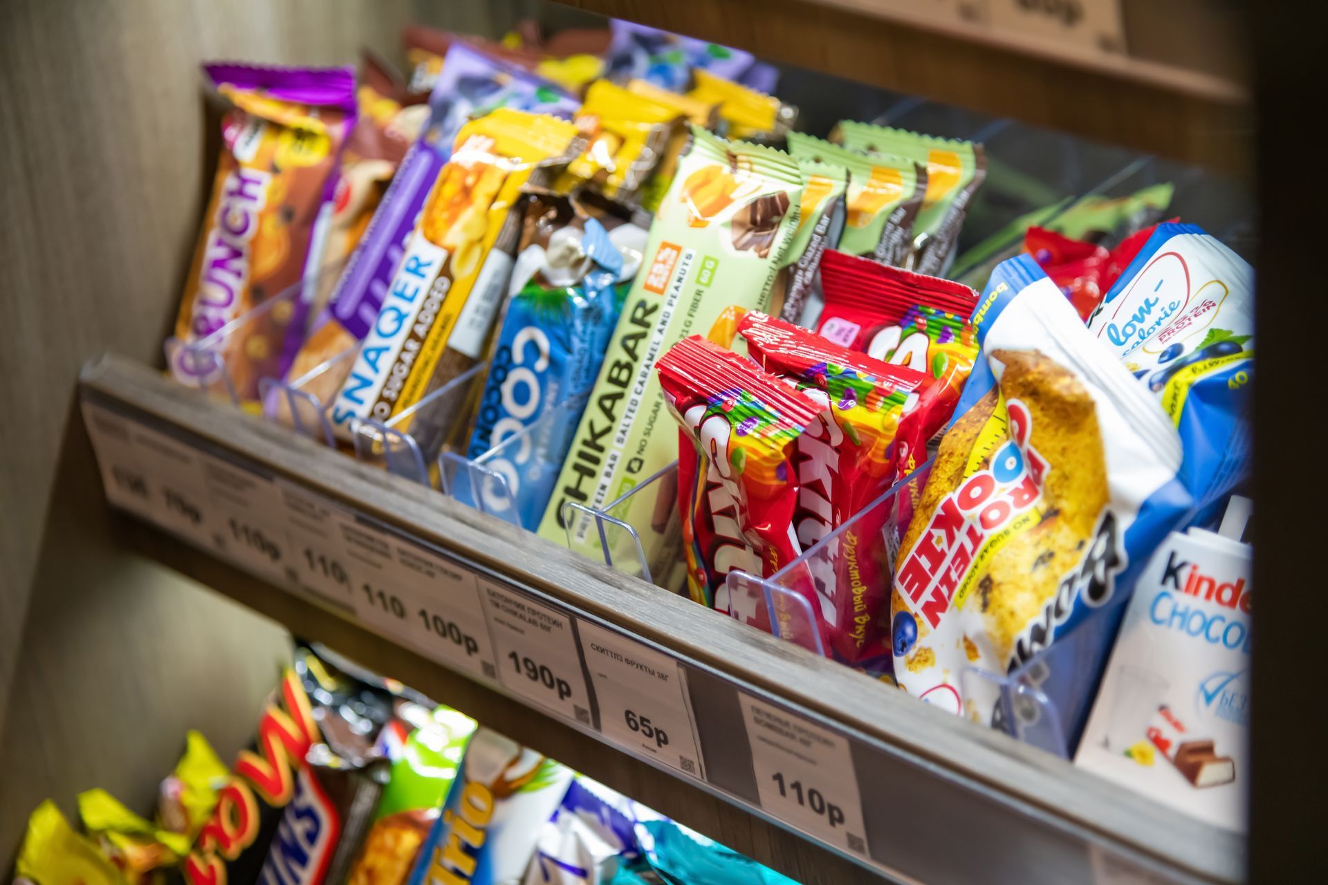 Colorful snack bars and candy packets displayed on a store shelf