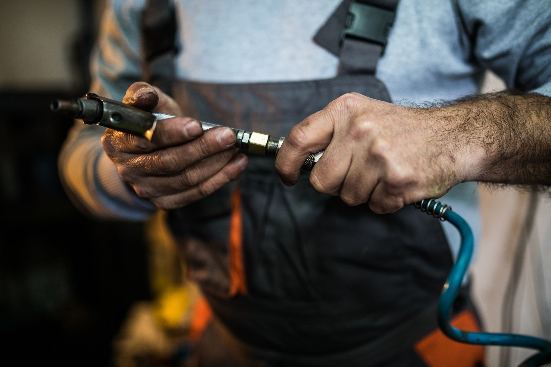 Technician assembling hydraulic hose with coupling fitting. Technician assembling hydraulic hose with coupling fitting.