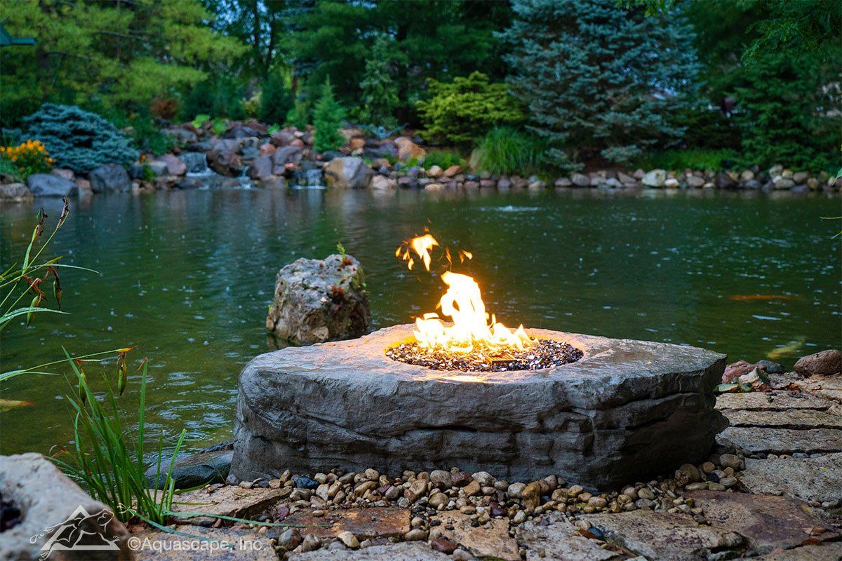 There is a fire pit in the middle of a pond.