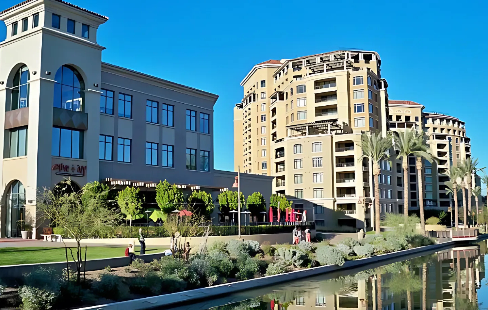A large building with a lot of windows is next to a body of water.