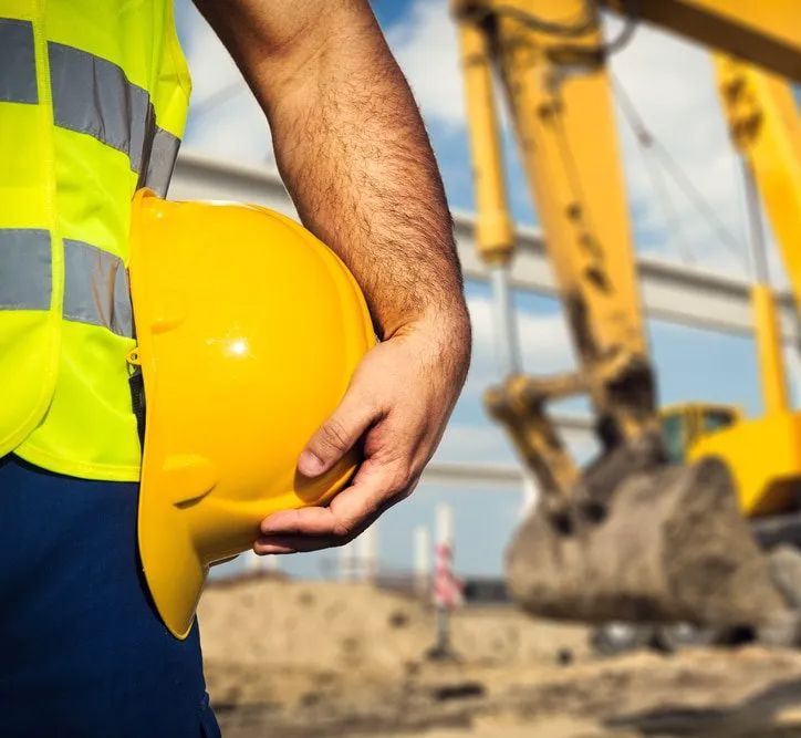 Construction worker holding yellow safety hat