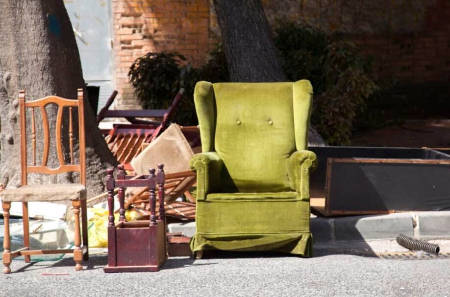 A green chair is sitting in the middle of a pile of chairs.