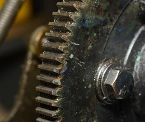 A close up of a rusty gear on a machine.