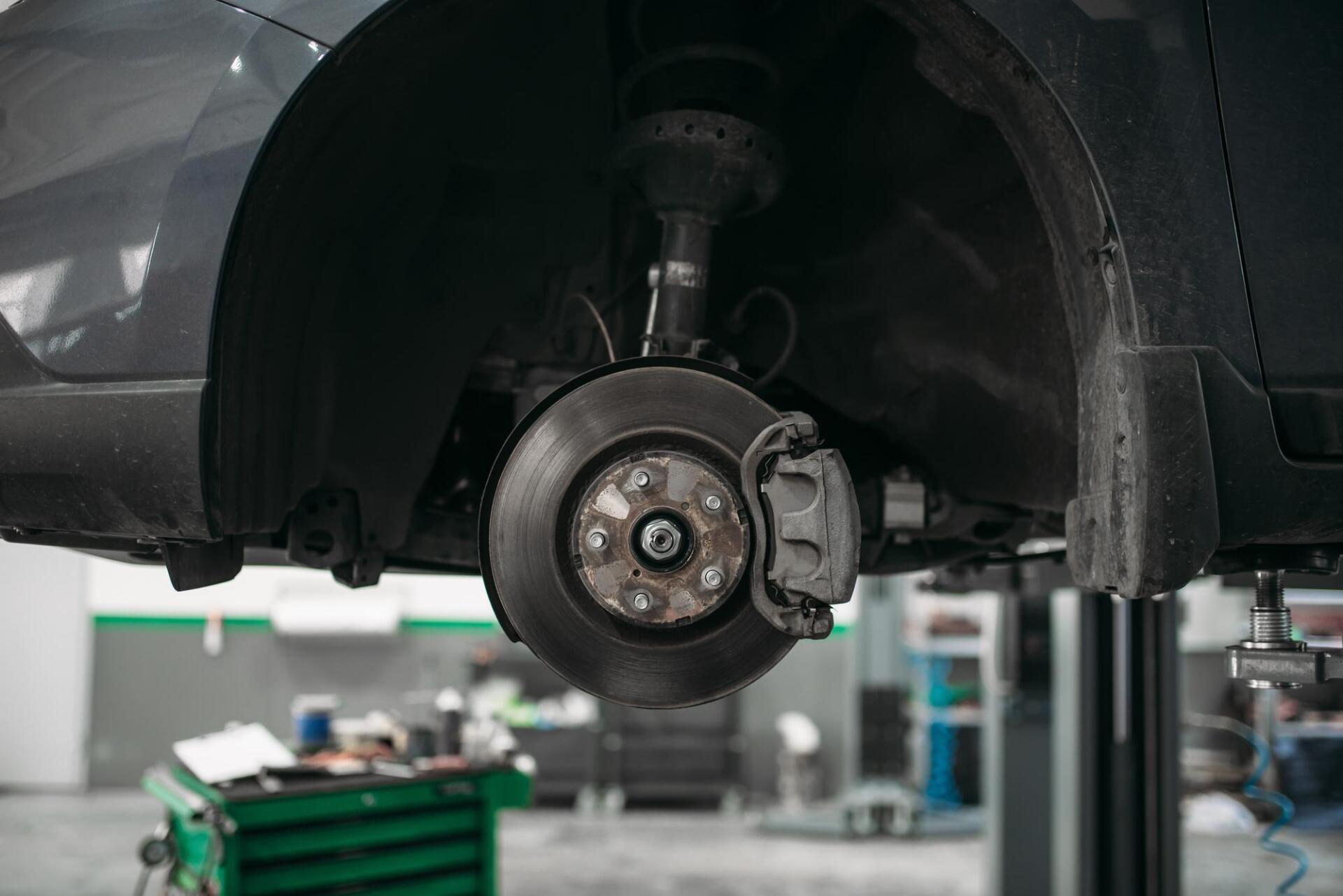 A car is sitting on a lift in a garage.