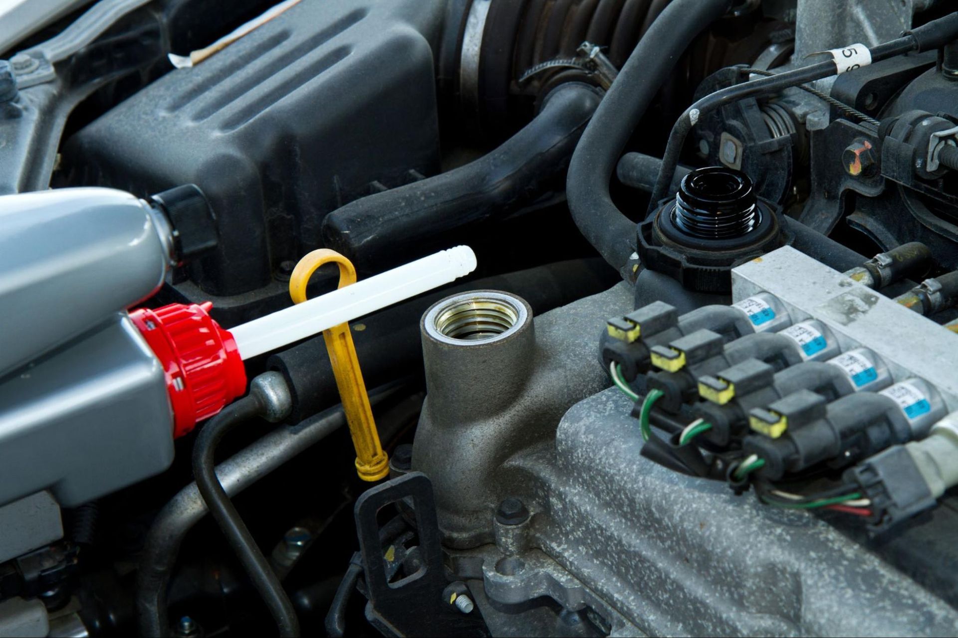 A close up of a car engine with a bottle of oil on it.