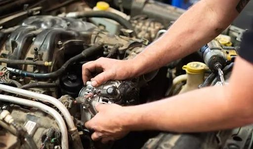 A man is working on the engine of a car.