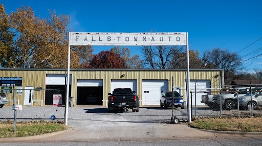 A truck is parked in front of a building that says fallton auto.