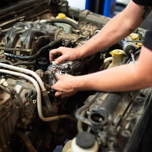 A man is working on the engine of a car.