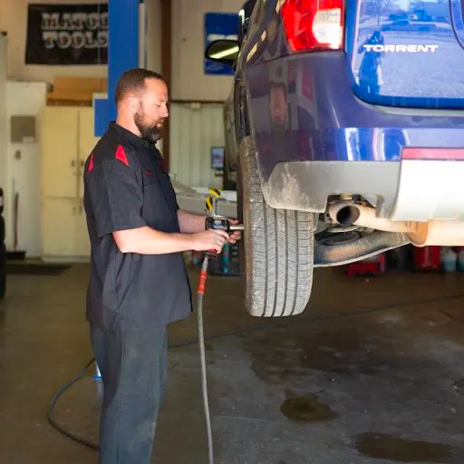 A man is working on a blue torrent in a garage