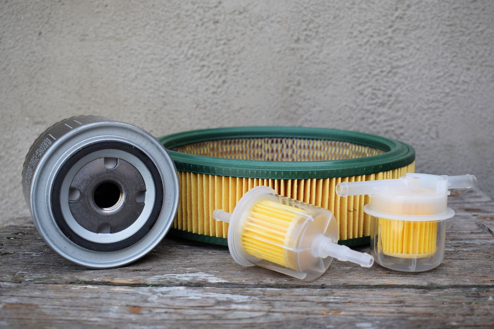 Three fuel filters are sitting on a wooden table.