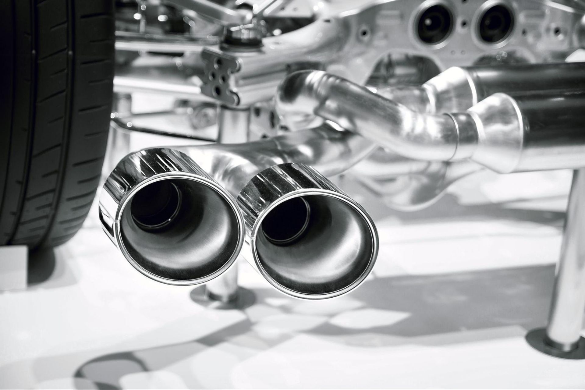 A black and white photo of a car exhaust pipe.