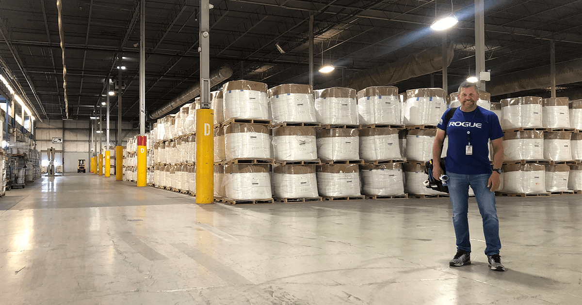 Darryl Legge, Facility Superintendent, smiling for the camera with the facility warehouse behind him