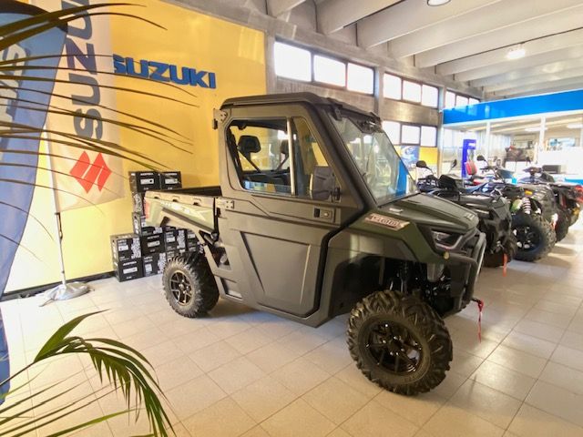 Veicolo fuoristrada nero parcheggiato al chiuso con i fari accesi e un gancio di traino rosso.