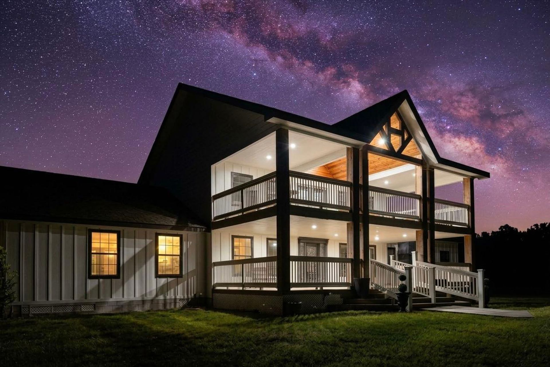 The Greystone Estate farmhouse lit up at night under the Milky Way in Kennard, Texas