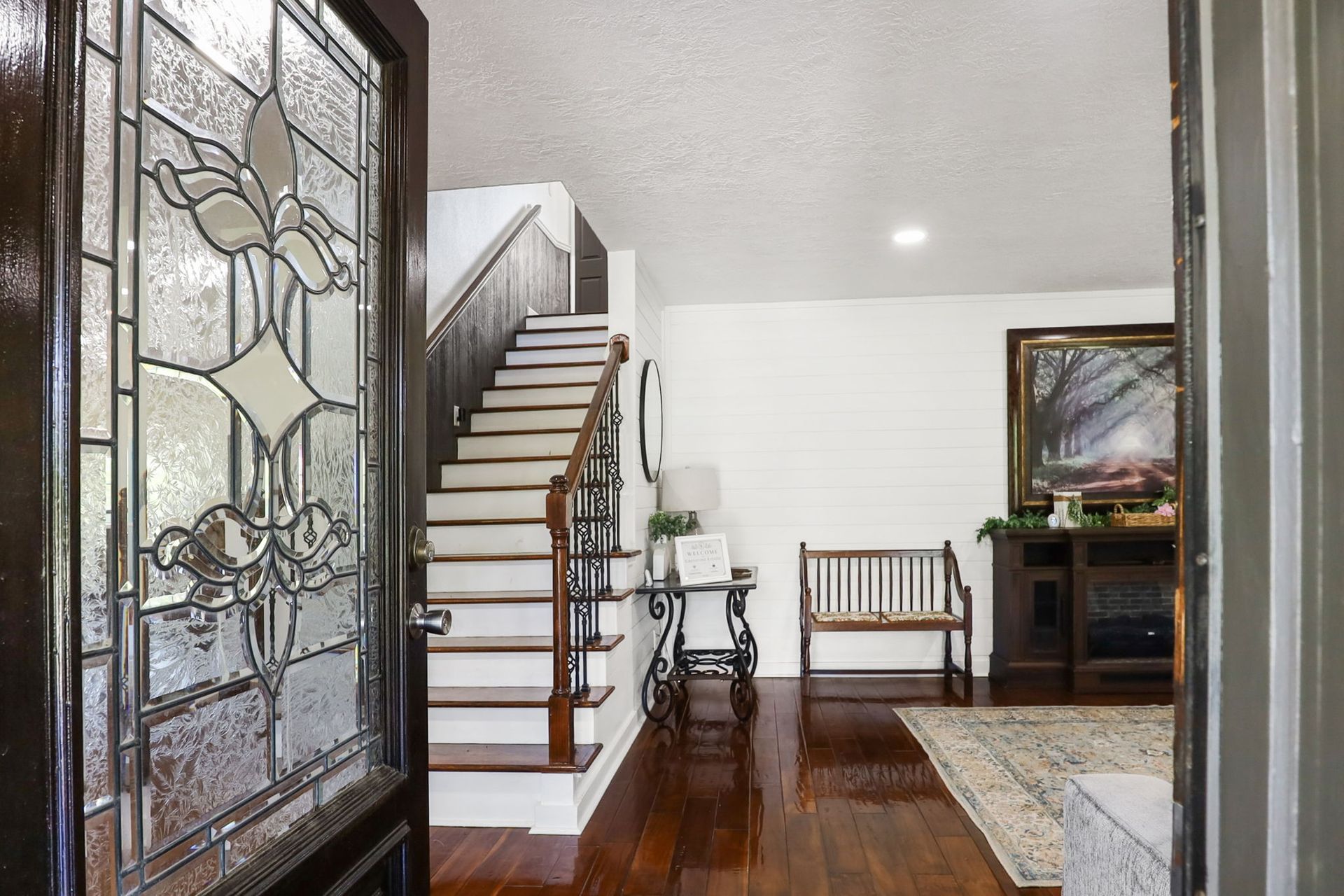 Entryway with stained glass door and staircase
