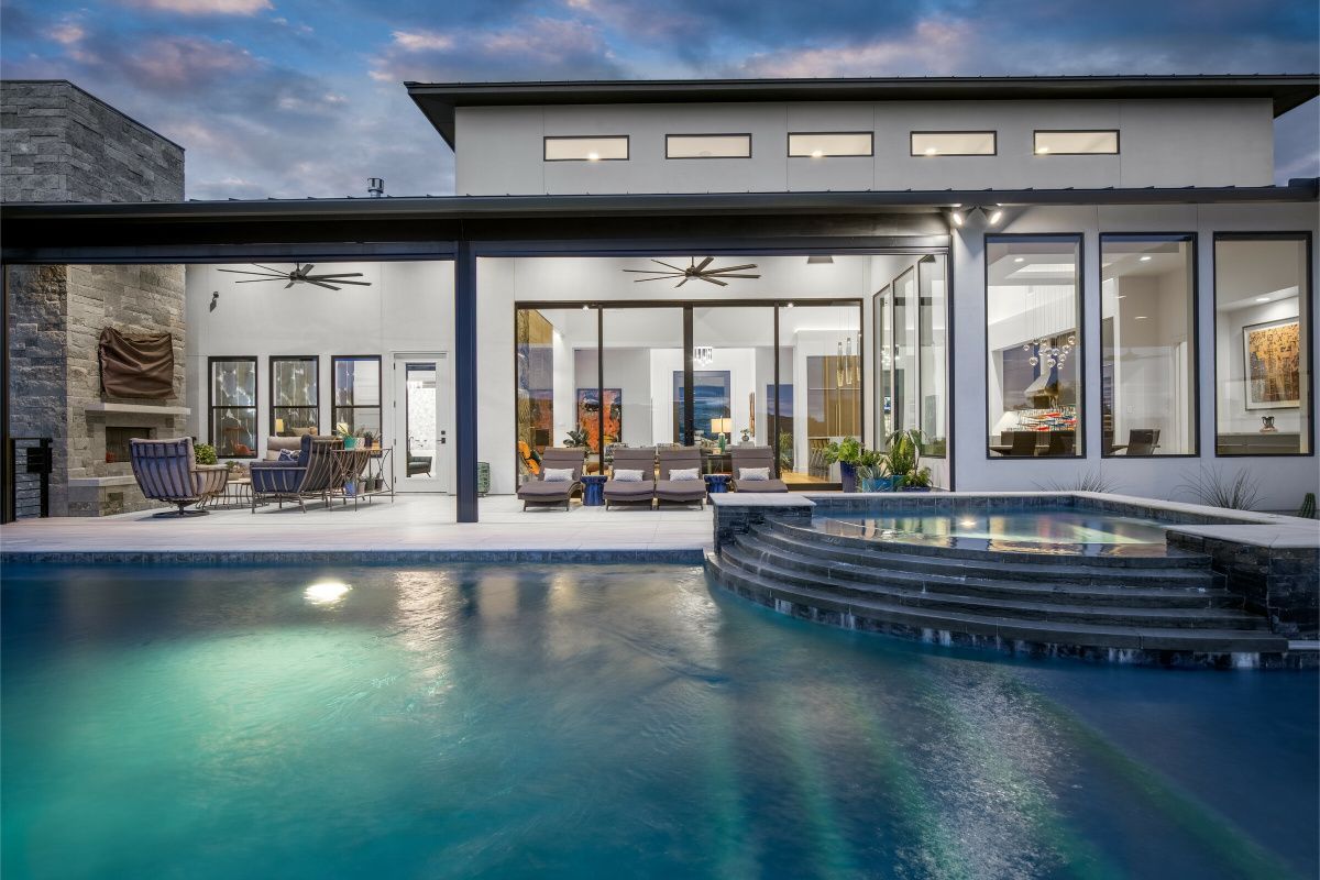 A large house with a large swimming pool in front of it.