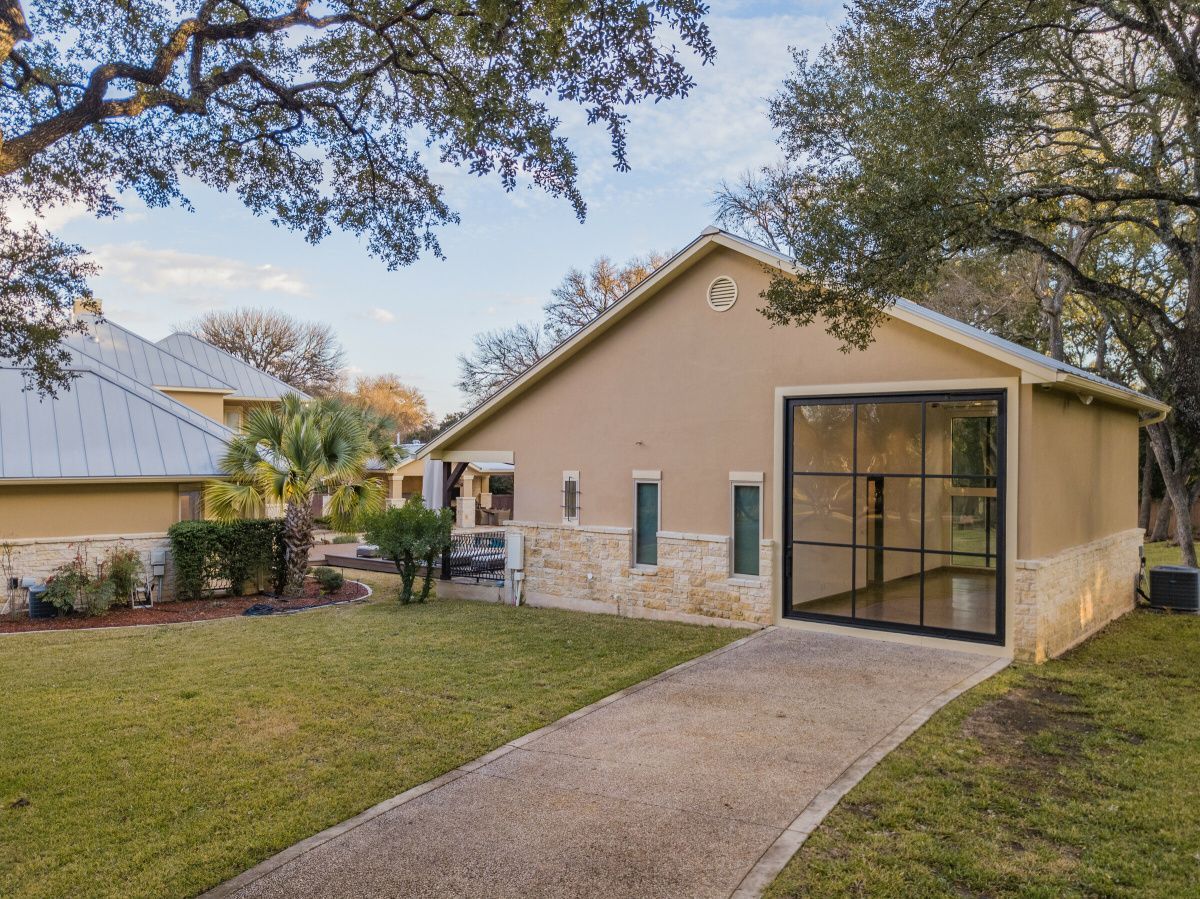 A house with a garage and a walkway leading to it.