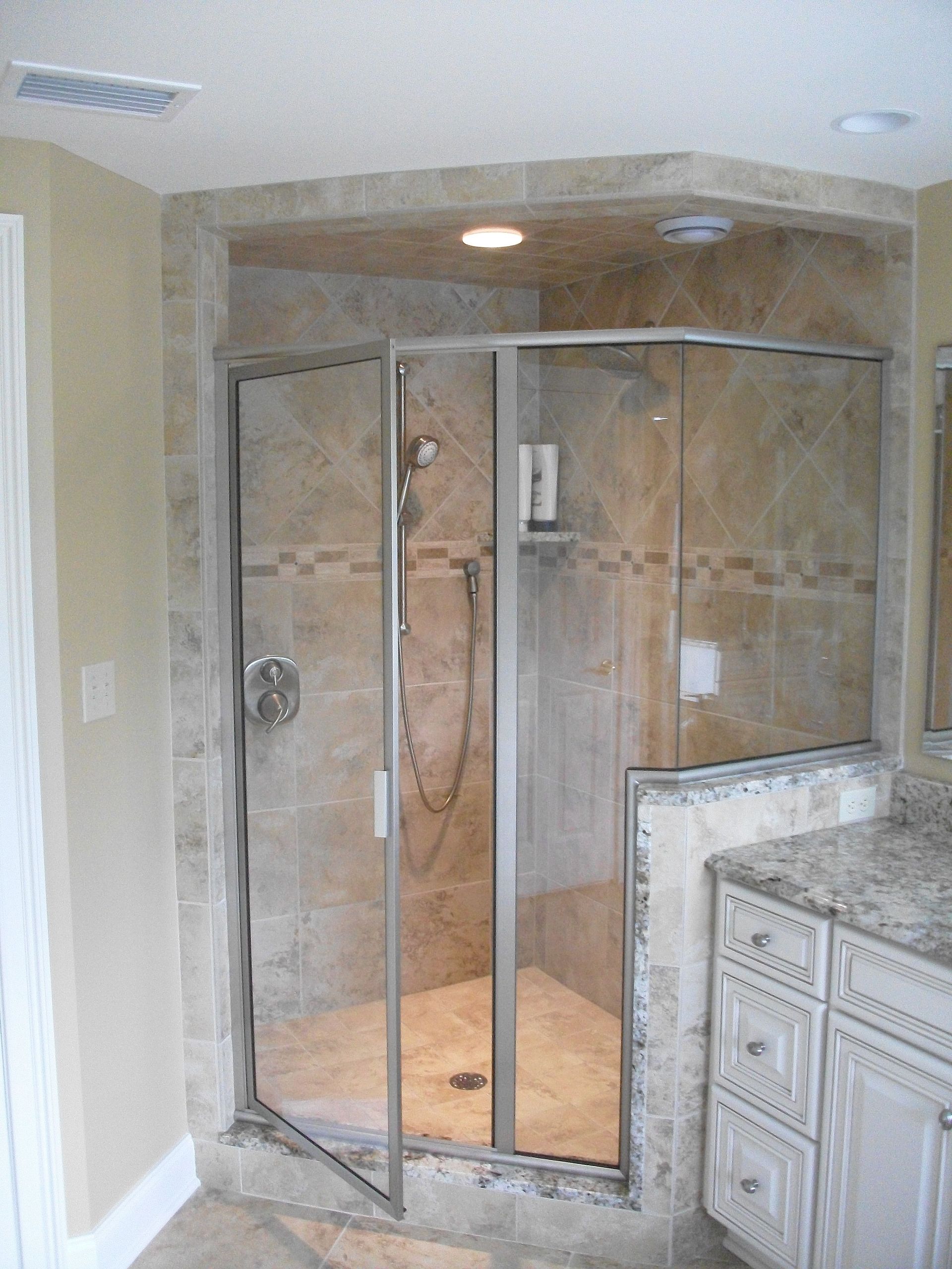A bathroom with a walk in shower and a vanity.