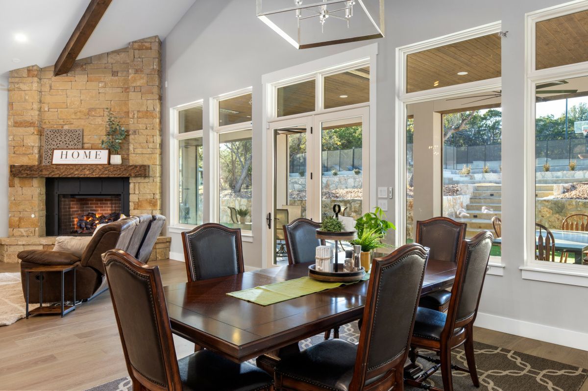 A dining room with a table and chairs and a fireplace.