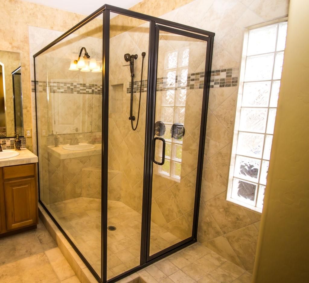 A bathroom with a walk in shower and a sink