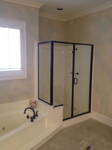 A bathroom with a bathtub and a shower stall