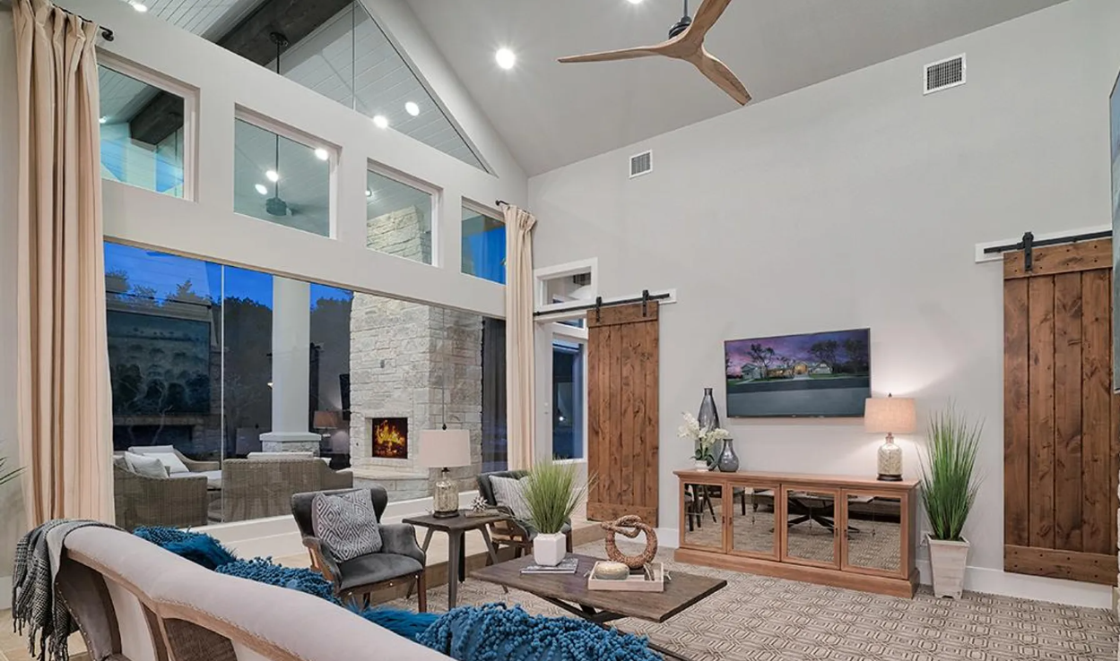 A living room with a couch , table , chairs and a ceiling fan.