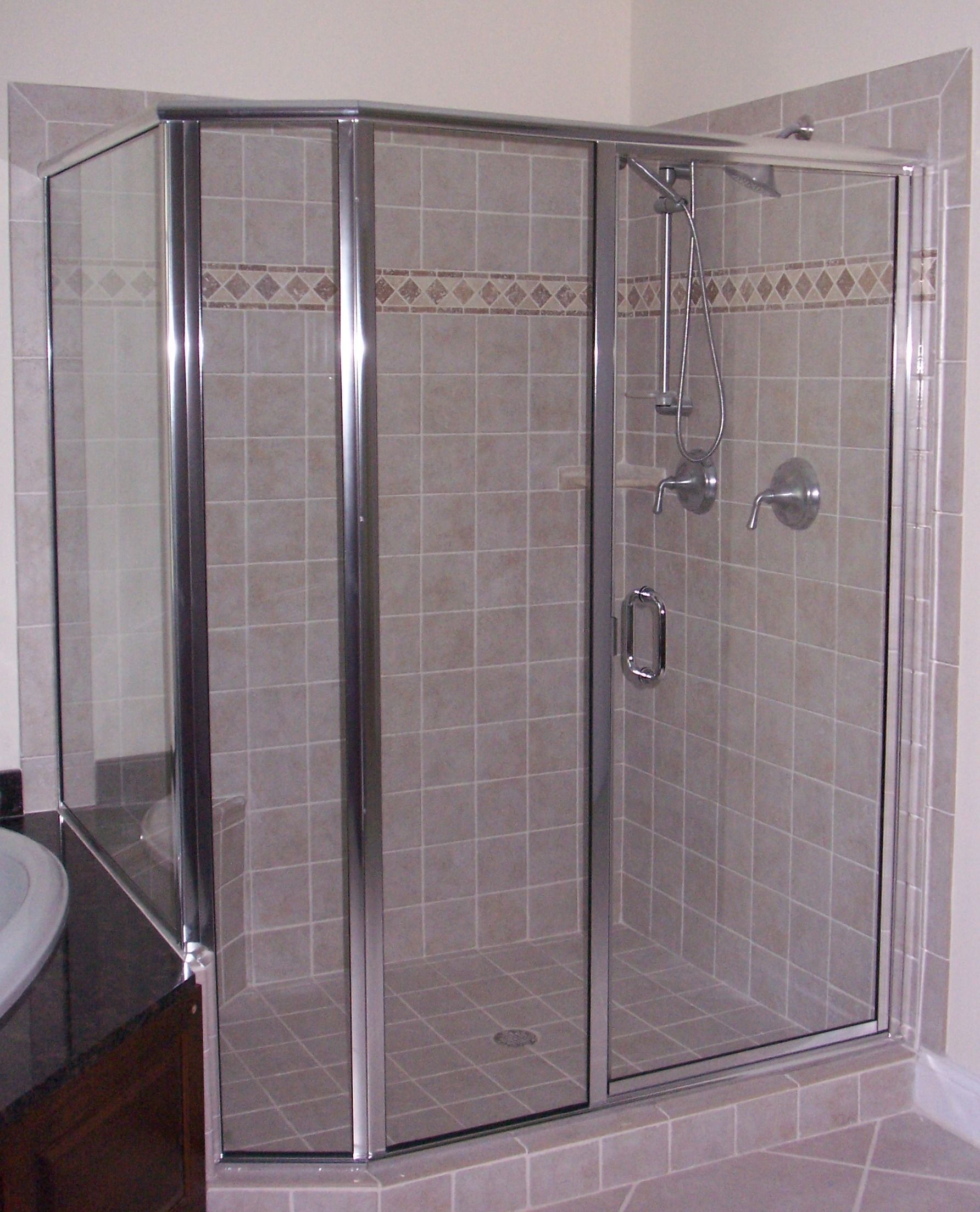 A bathroom with a walk in shower with a glass door