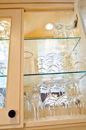 A shelf filled with wine glasses in a cabinet.