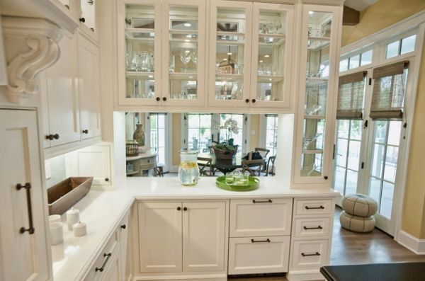 A kitchen with white cabinets and glass doors