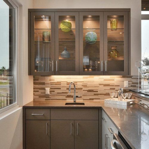 A kitchen with brown cabinets and glass doors