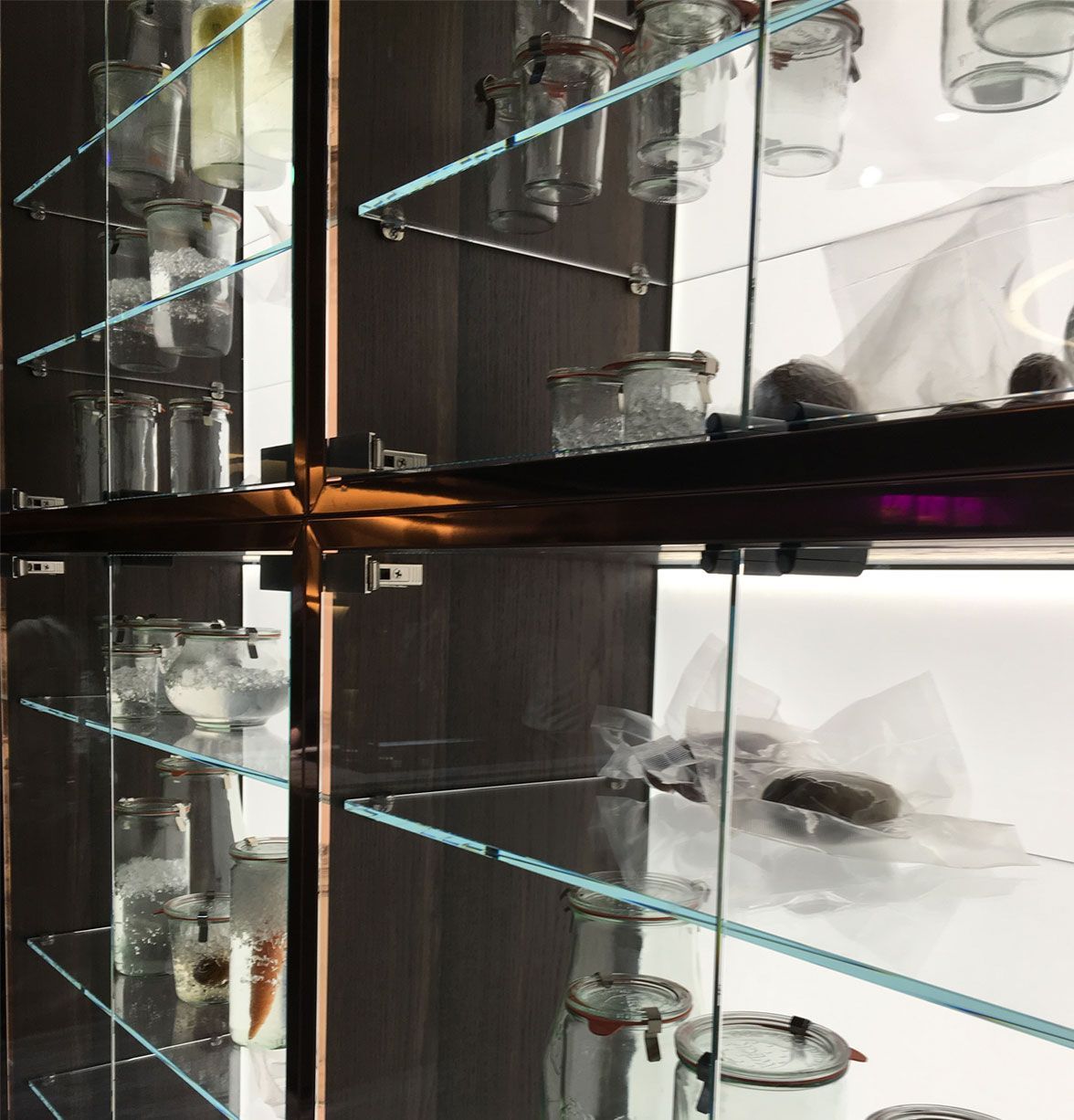 A glass cabinet filled with jars and glasses