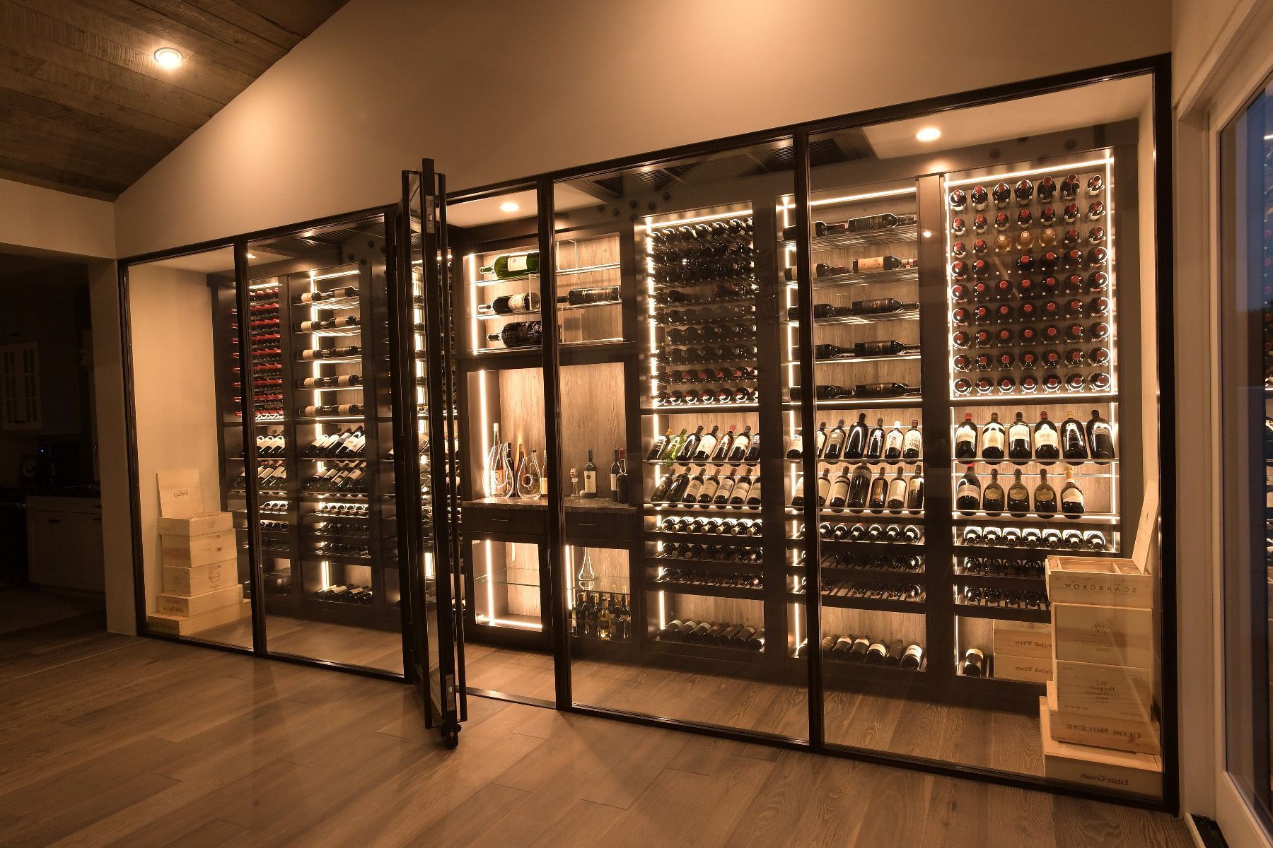 A large wine cellar filled with lots of wine bottles and glasses.