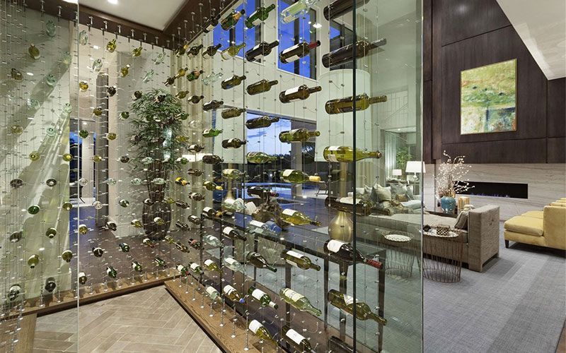 A wine cellar with lots of wine bottles hanging from the ceiling