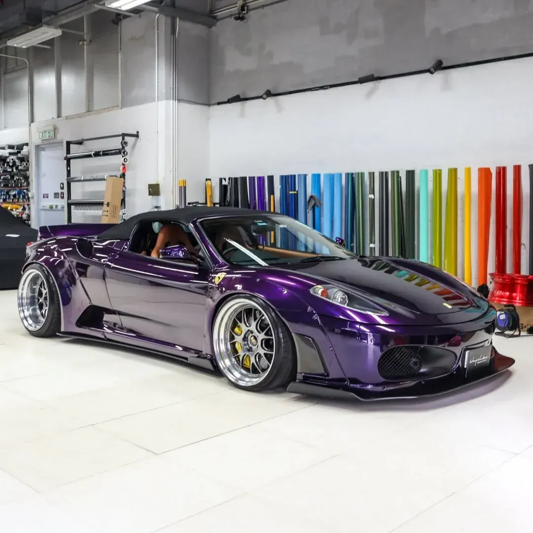 Purple sports car in a garage with colorful vertical panels on the wall