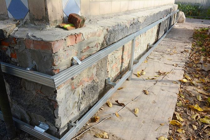 A brick wall with a metal frame attached to it.