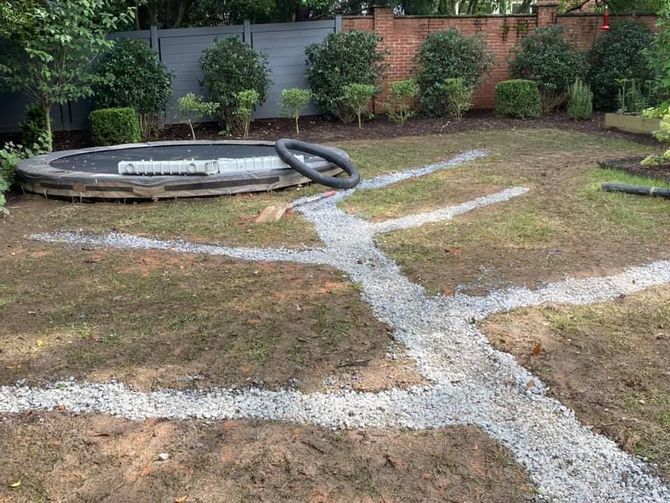 A trampoline is sitting in the middle of a lush green yard.