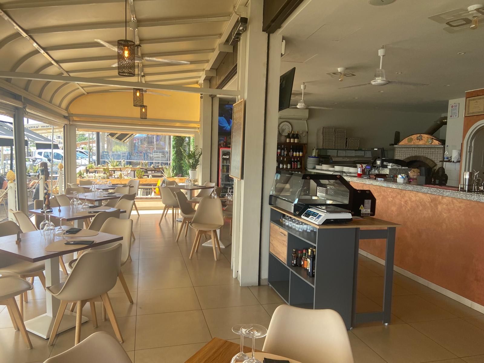 Un ristorante con tavoli, sedie e un bancone.
