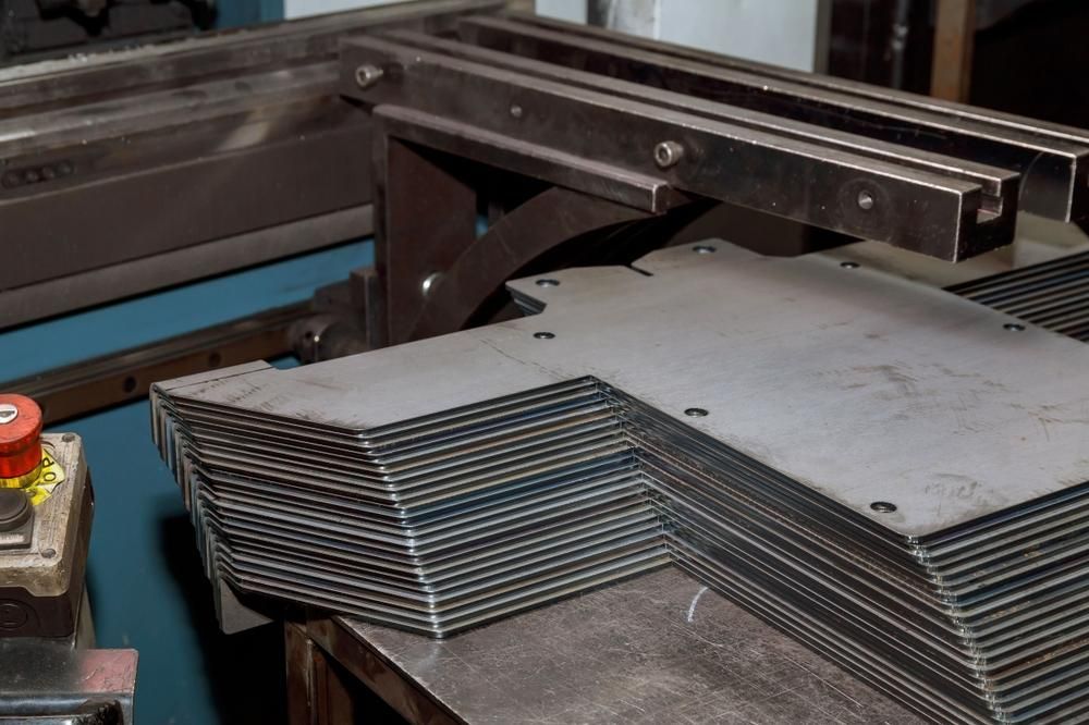 A Stack of Metal Sheets Sitting on Top of A Table — K & S Sheetmetal in Gladstone Central, QLD