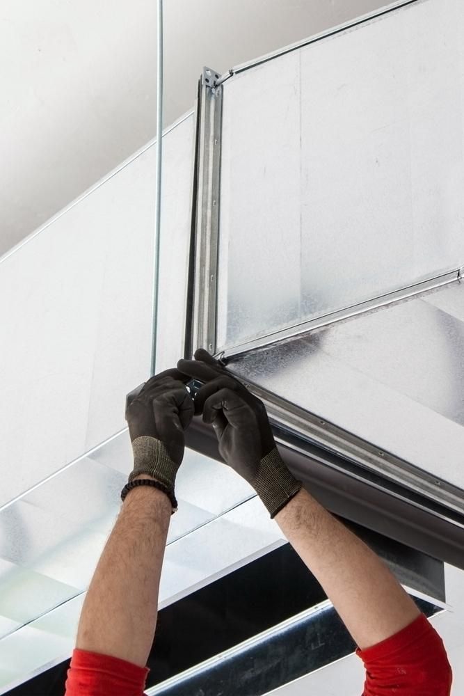 A Man Wearing Gloves Is Working on A Ceiling Fan — K & S Sheetmetal in Gladstone Central, QLD