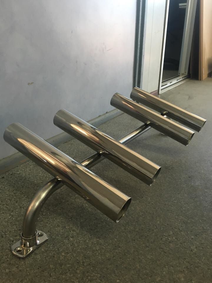 A Row of Stainless Steel Fishing Rods Are Sitting on A Carpeted Floor — K & S Sheetmetal in Gladstone Central, QLD
