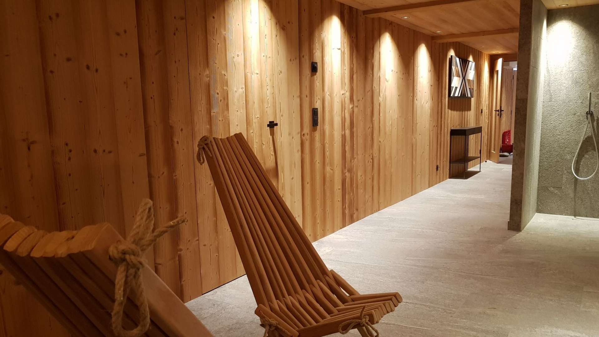 Armoire en bois encastrée dans le mur d'une chambre, partiellement ouverte, avec un lit au premier plan.;