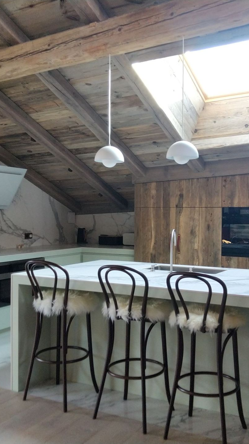 Un salon avec un canapé, des chaises, une cheminée et un écran de projection.
