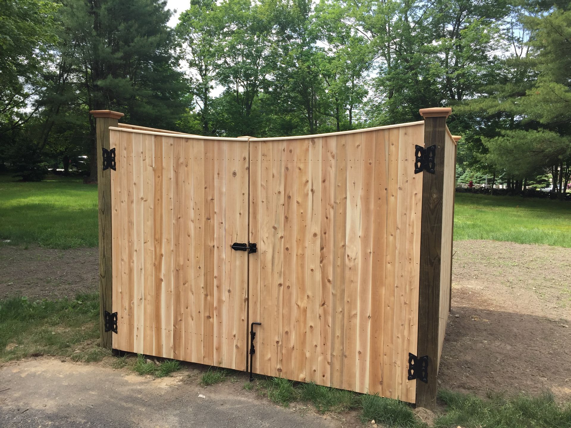 A wooden gate is sitting in the middle of a grassy field.