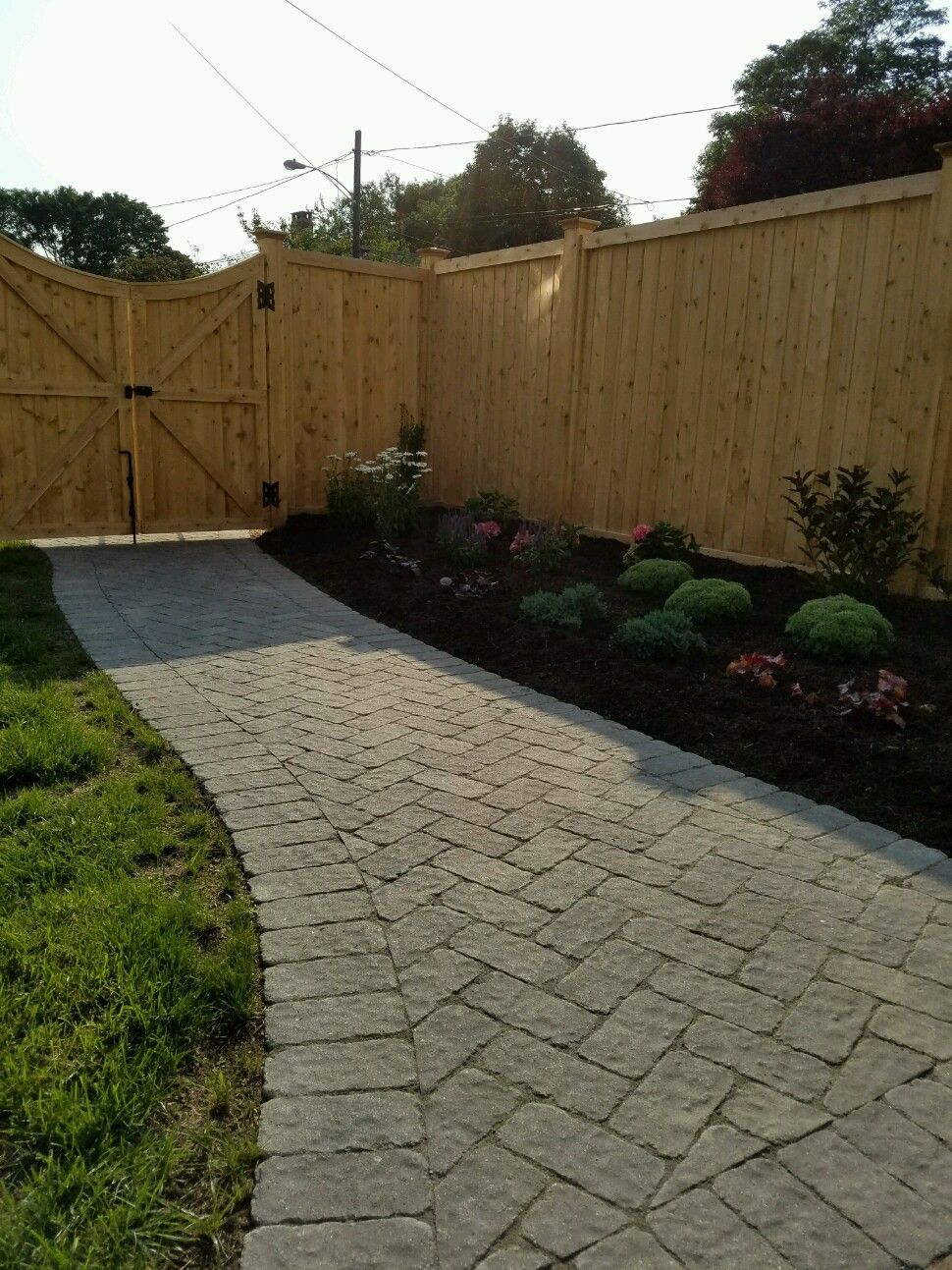 A wooden fence with a stone walkway leading to it