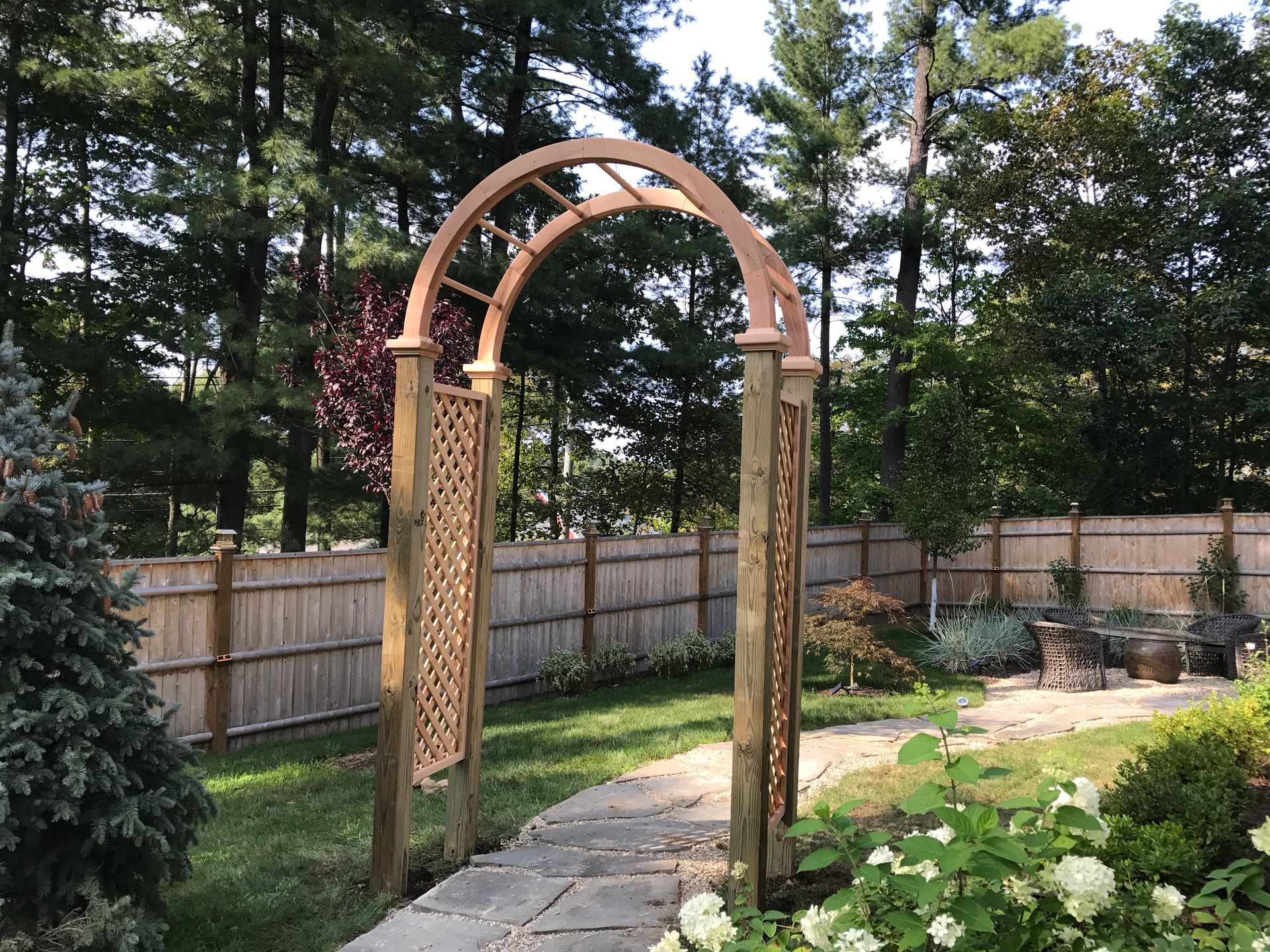 There is a wooden arch in the middle of a garden.