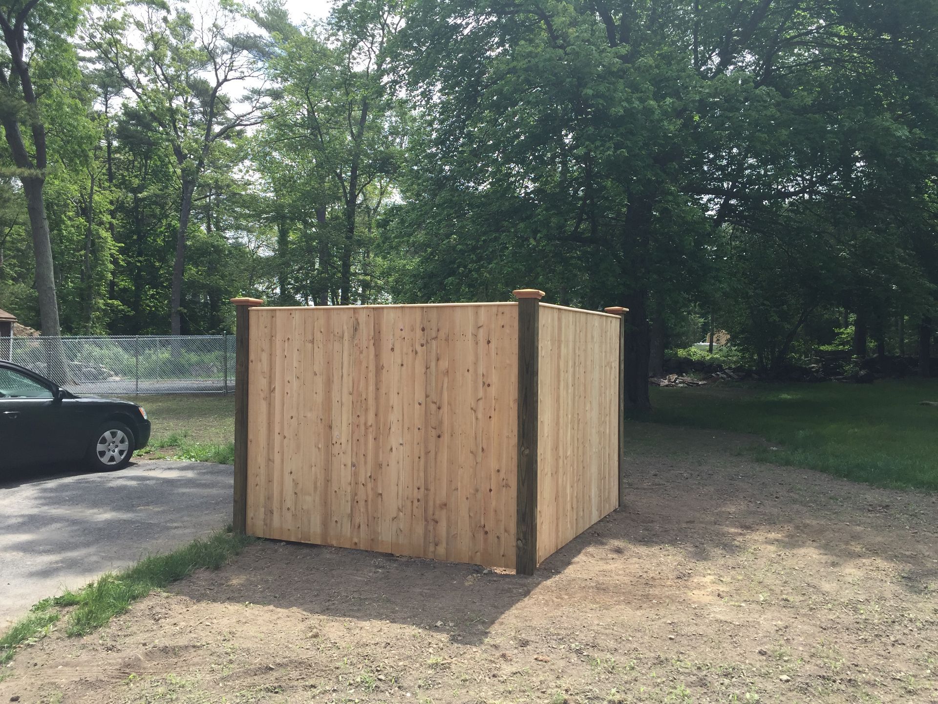 A wooden fence is sitting in the middle of a dirt field.