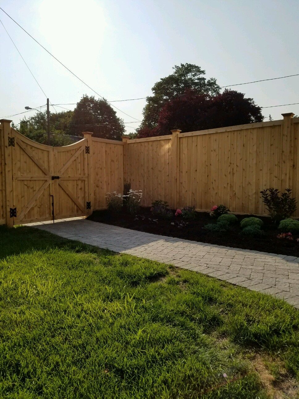 A wooden fence with a gate in the backyard.