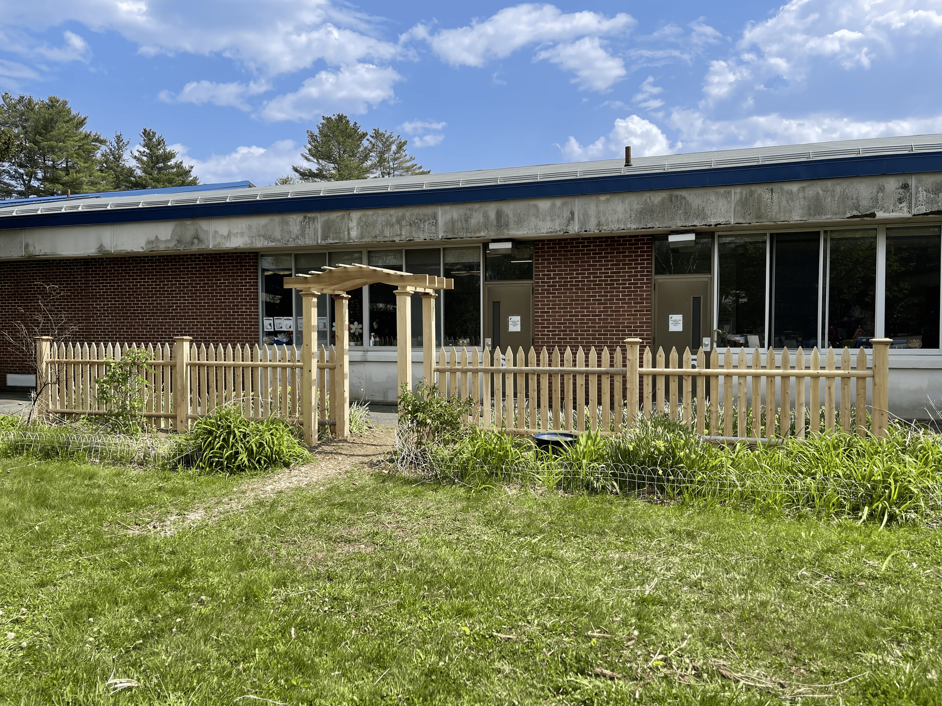 There is a wooden fence in front of a building.