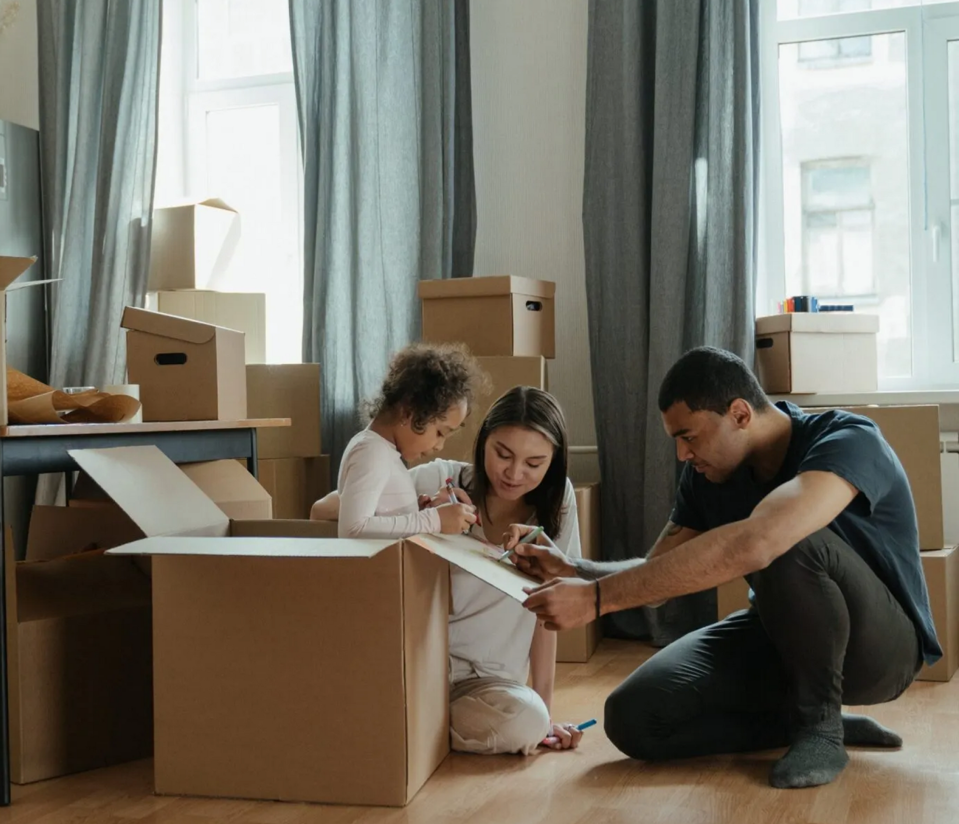 A family is moving into a new home and playing with cardboard boxes.